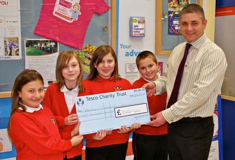 Children from heath Primary School receive their donation cheque from Tesco Store Manager, Michael Cooke