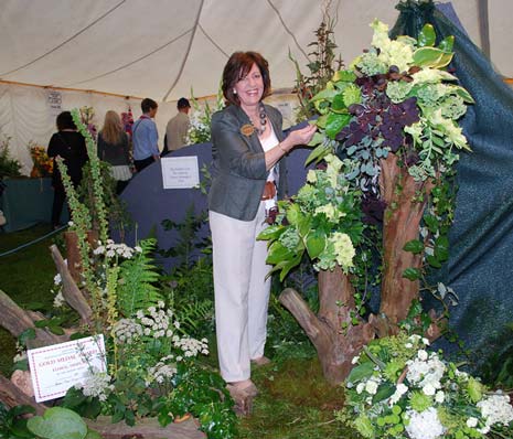 Ashover Flower Arrangers' chairman Mrs Jenny Savidge puts the final touches to the club's innovative presentation.