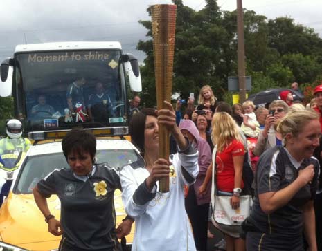 Sam carries the torch aloft as the first leg torch bearer for Chesterfield today.