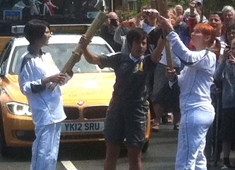 Sam carries the torch aloft as the first leg torch bearer for Chesterfield today.