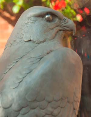 Sitting inside a clear dome is a sculpture of a peregrine falcon sitting on an ice rock