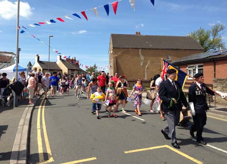 At 12 Noon precisely, in glorious sunshine, hundreds of villagers including parents and children from New Whittington Primary School, and led by Standard Bearers from the branch of the New Whittington British Legion, paraded through the High Street to applause and song, and a member of the Community Association Committee duly declared the Gala open.