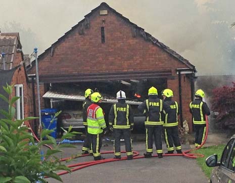 A double car garage, with two cars inside, is virtually destroyed by the fire next door on Stone Lane