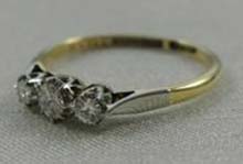 The ring pictured  is a three-stone diamond ring with old cut, round diamonds mounted in 18ct gold (stamped) and platinum set, pierced beneath stones.